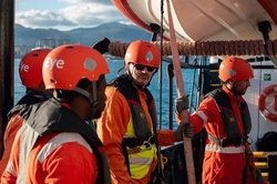 Quelle: Sea-Eye Das Rettungsteam in Ausrüstung mit Helm und Kleidung in Signalfarben auf dem Deck . Johannes Schweigler blickt in die Kamera.
