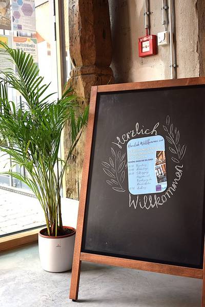 Aufsteller mit dem Flyer für die Einweihung und "Herzlich Willkommen"-Schriftzug